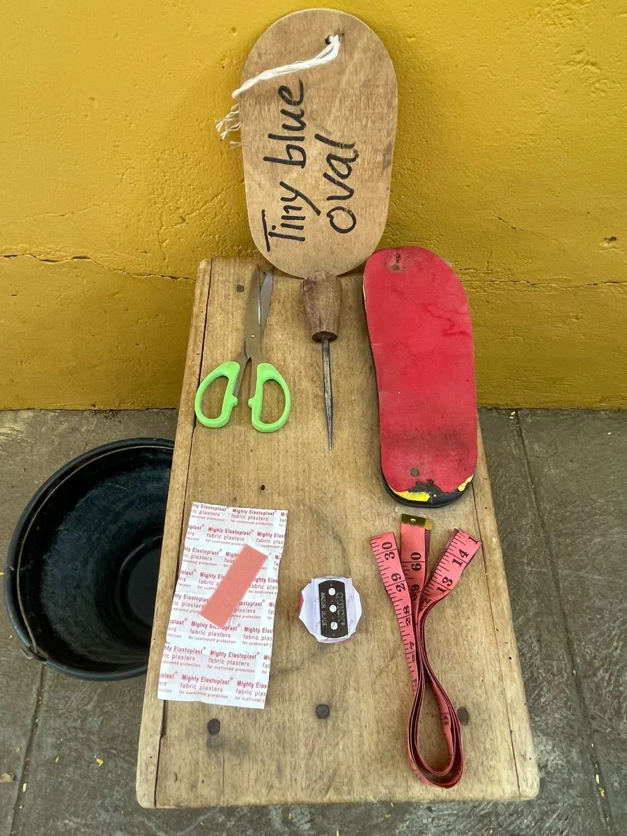 Basket weaving tools, tape measures, scissors, blades and plasters on a wooden bench