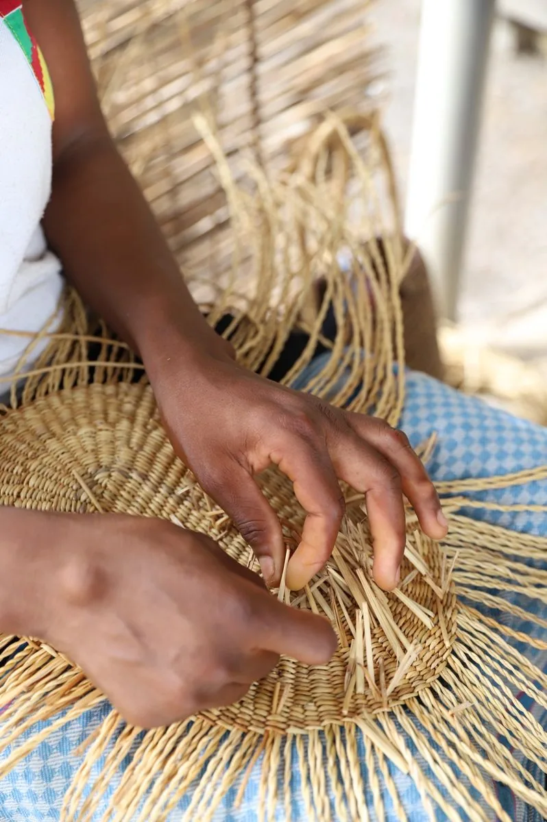 A basket maker shaping the woven base by hand