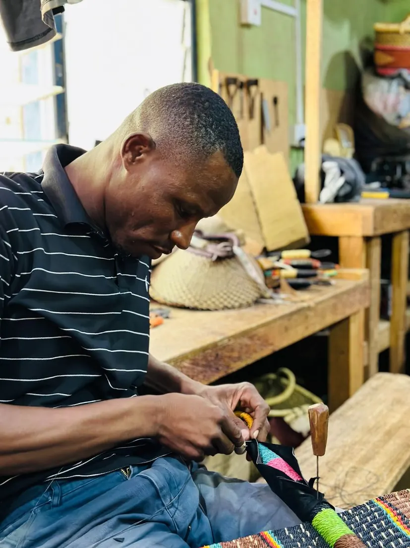 A leather worker shaping and attaching leather to a basket